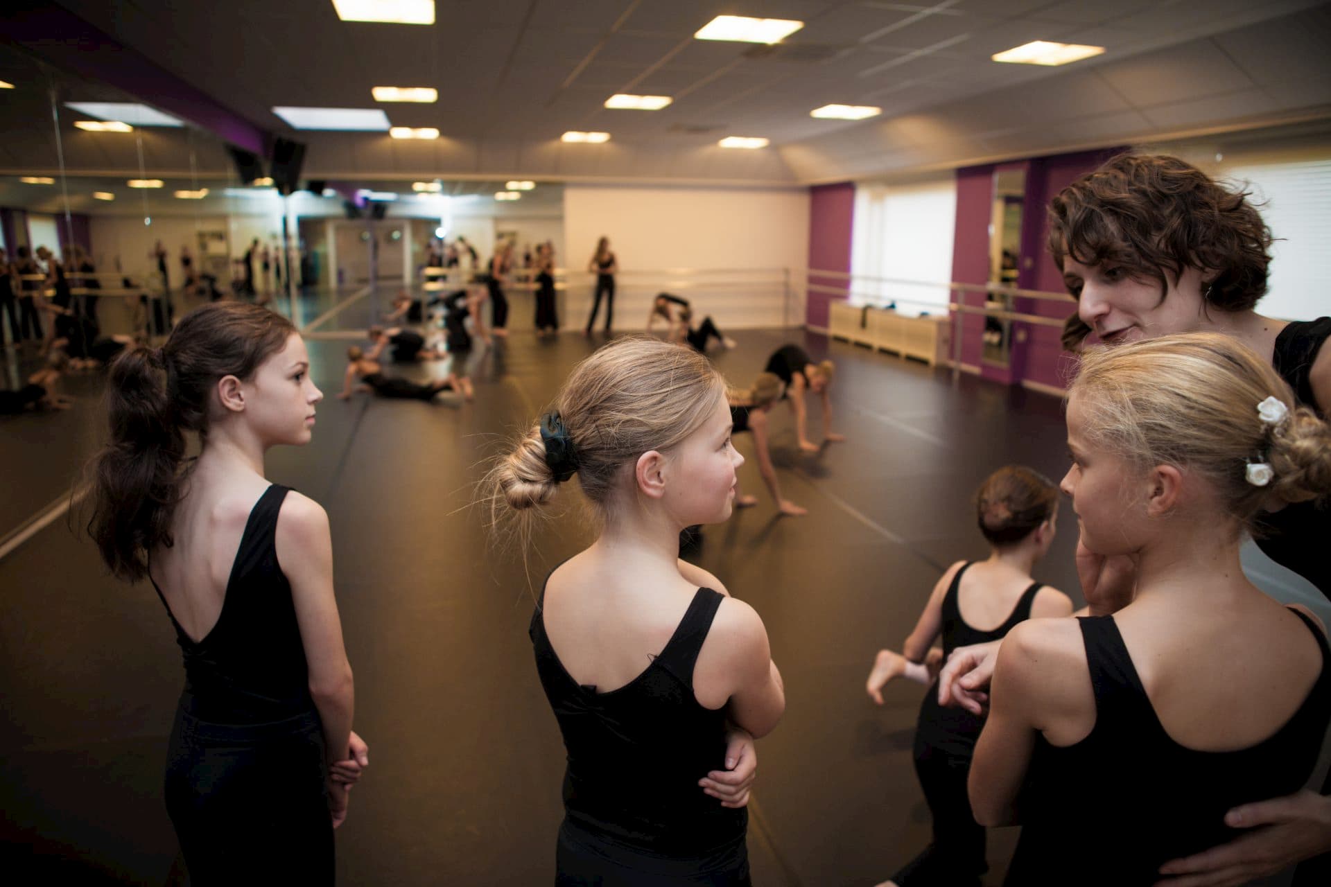 Balletschool Heerhugowaard dansles dans les geven zwarte pakjes leerlingen juf dansjuf uitleggen danszaal